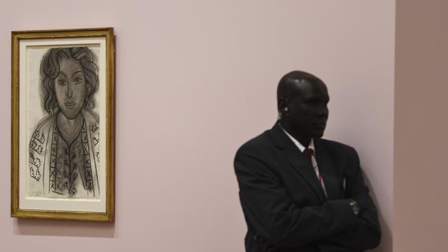 A security guard with Matisse’s portrait of Lydia Delectorskaya, titled The Romanian Blouse, at the National Gallery of Australia. Picture: Lukas Coch/AAP