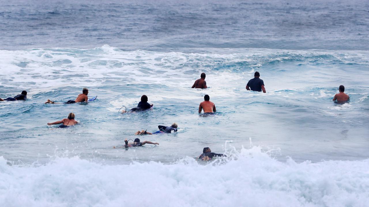 Surfers line up for a wave at Burleigh Heads as wet weather descended over the Gold Coast. Photo: Scott Powick NEWSCORP