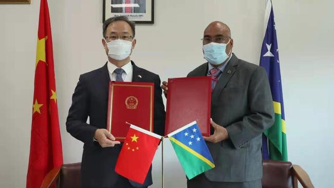 Chinese ambassador H.E. LI Ming and the Solomon Islands’ Permanent Secretary of the Ministry of Foreign Affairs and External Trade Colin Beck with the Framework Agreement Between the Government of the PRC and the Government of Solomon Islands on security cooperation.