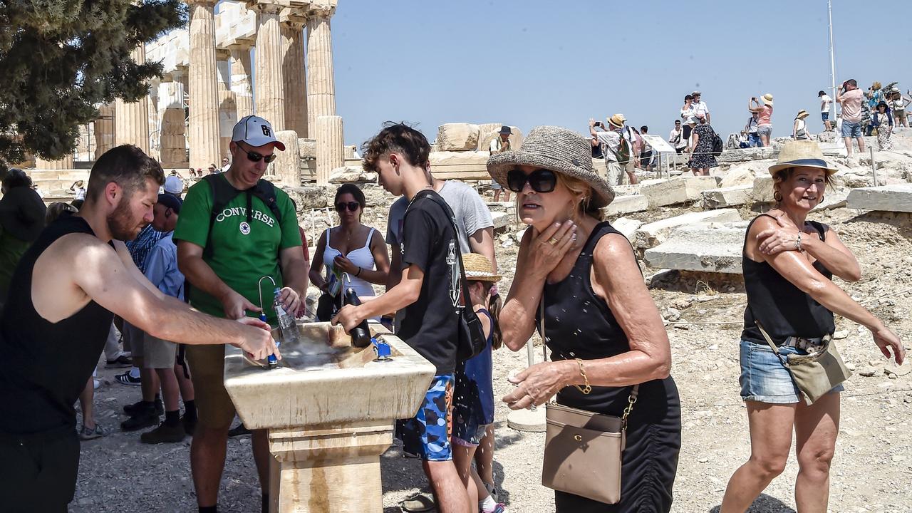 Tourists trying to cool down in front of the Parthenon temple at the Acropolis in Greece during a heatwave on July 20. Picture: Milos Bicanski/Getty Images