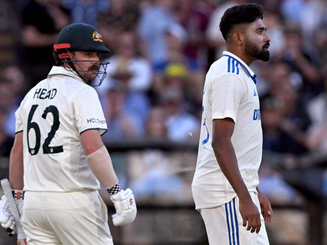 Australian batsman Travis Head (L) looks at Indian bowler Mohammed Siraj (R) on the second day of the second Test cricket match between Australia and India at the Adelaide Oval in Adelaide on December 7, 2024. (Photo by William WEST / AFP) / -- IMAGE RESTRICTED TO EDITORIAL USE - STRICTLY NO COMMERCIAL USE --