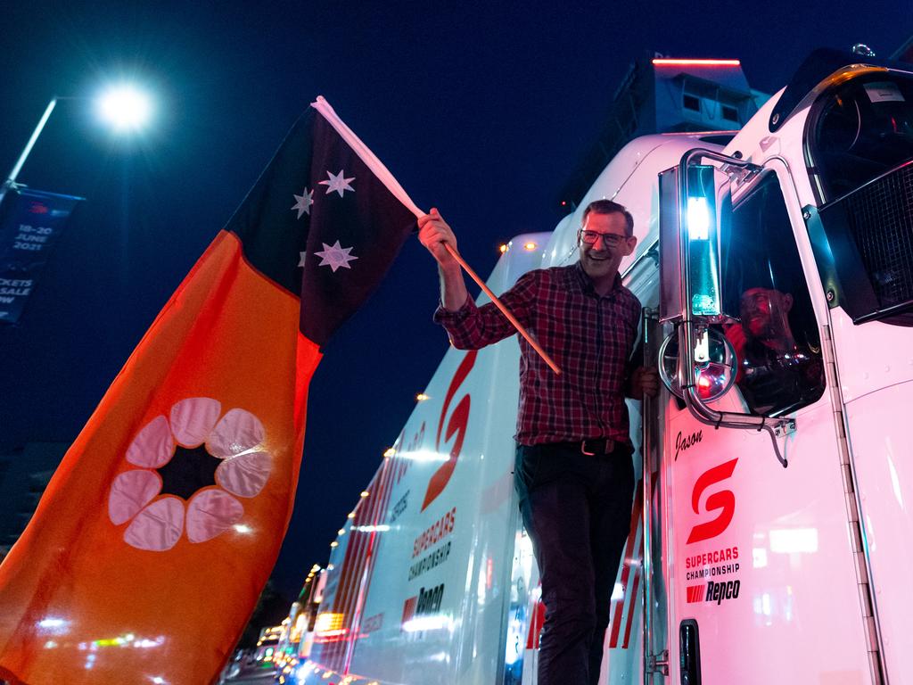 A convoy of trucks arrives in Darwin's CBD to announce the arrival of the Supercars for the round at Hidden Valley Raceway. Chief Minister Michael Gunner waves the Territory flag to get proceedings underway. Picture: Che Chorley