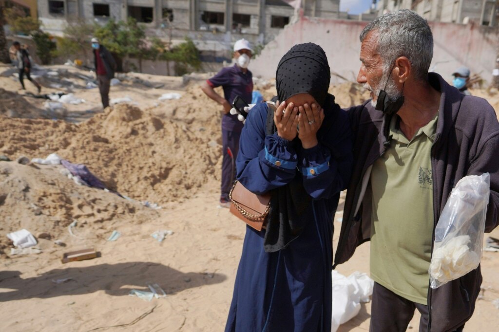 Palestinians react after the body of a relative was found buried at the Nasser hospital in southern Gaza