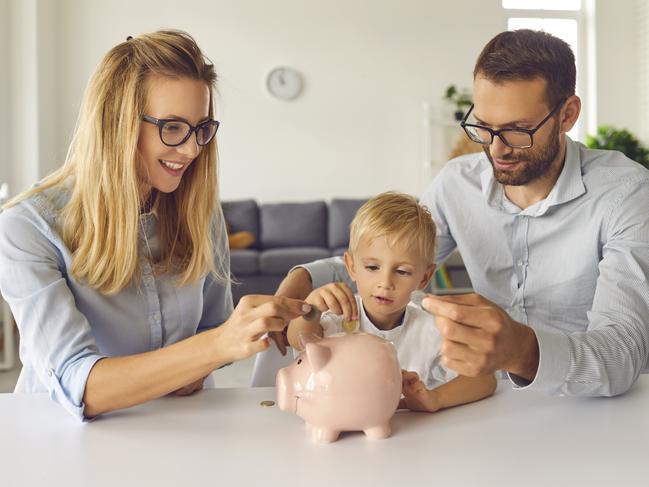 Child puts money inside piggy bank, learns to effectively manage budget and spend wisely from young independent parents able to provide high living standard. bank of mum and dad, kids financial literacy concept