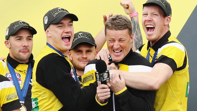 Dustin Martin and Jack Riewoldt hug Tigers head coach Damien Hardwick.