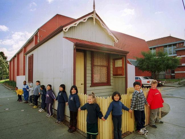 Collingwood College students join hands outside the Doll’s House which is believed to be the smallest home in the country