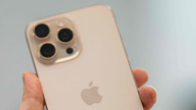 A person holds up a new iPhone 16 Pro following Apple's "It's Glowtime" event in Cupertino, California, September 9, 2024. (Photo by Nic COURY / AFP)