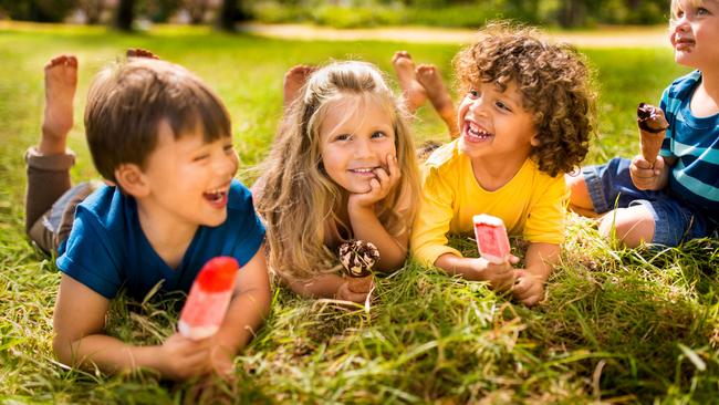 Boys and girl happily enjoying ice creams and popsicles in the park