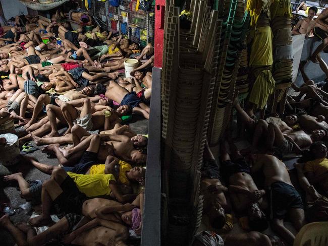 Men take turns to sleep on the cracked cement floor of an open-air basketball court, the steps of staircases, as well as underneath beds and hammocks made out of old blankets. Picture: Ayee Macaraig