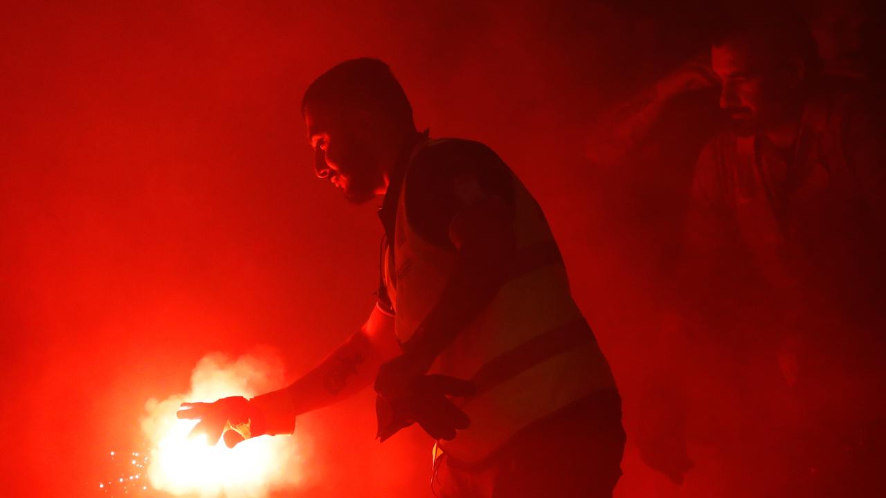 A supporter marshal grabs a flare from WSW fans.