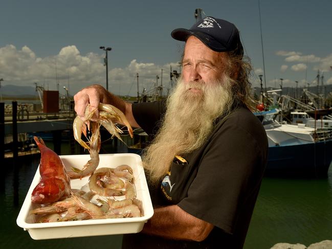 Lounds Seafood owner Col Lound with a coral trout and banana prawns with part of Townsville's fishing fleet. Picture: Evan Morgan