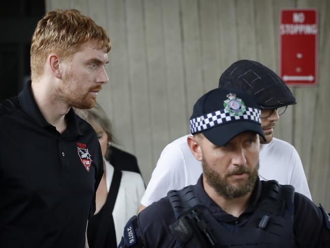 Britton Coulson (left) and Foster Coulson are escorted by AFP officers out of Sydney Airport. Picture: Chris Pavlich