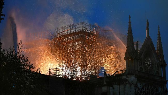 Flames are seen through the scaffolding of the Notre Dame. Picture: Stephane de Sakutin/AFP