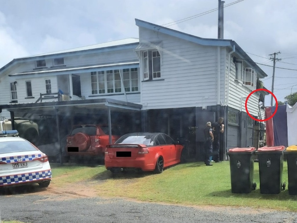 A neighbour's picture of the man holding what appears to be a gun on the balcony of the Sunnybank home.