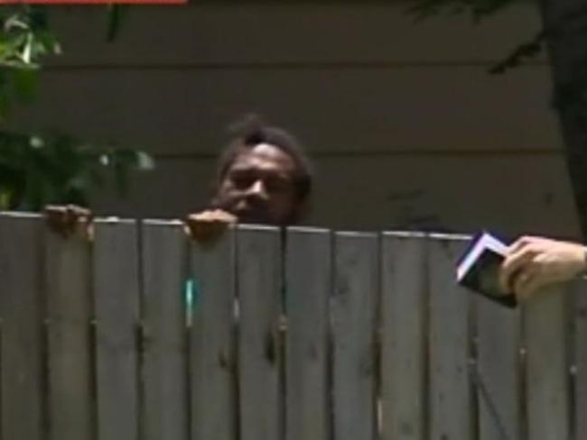 A man weeps behind a fence near the Murray St home where eight siblings have been found dead. Picture: Sky News