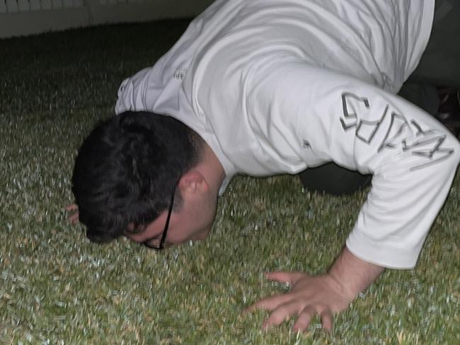 Drew Pavlou kissing the ground upon his return home to Australia. Picture: @DrewPavlou / Twitter