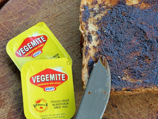 Reichenbach, Germany - 0ctober 4, 2013: Vegemite on Toast - Produce in Australia at Kraft Foods' Port Melbourne. It's a popular dark brown australian Food Paste - used as spread for sandwiches and toast - the Australian People love it for Breakfast. It taste similar to beef bouillon. I shot this photo at home in Germany - the Vegemite was a Souvenir from my Australia Trip. Toast with Knife and 2 small packages of Vegemite.