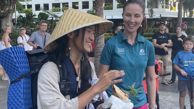 Councillor Amy Eden hands Uni a meat pie at the end of his 3000km journey.