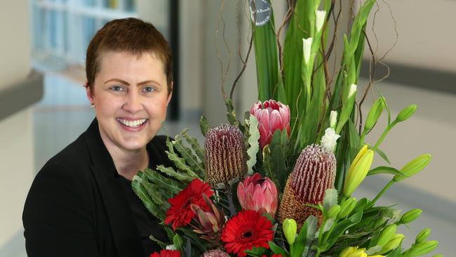 Patient Jessica Seeney, of Oran Park, accepts the bunch of flowers at Macarthur Cancer Therapy Centre.