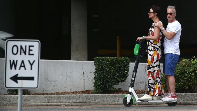 A woman and man ride a Lime-S Scooter together in Brisbane. Picture: AAP/Jono Searle