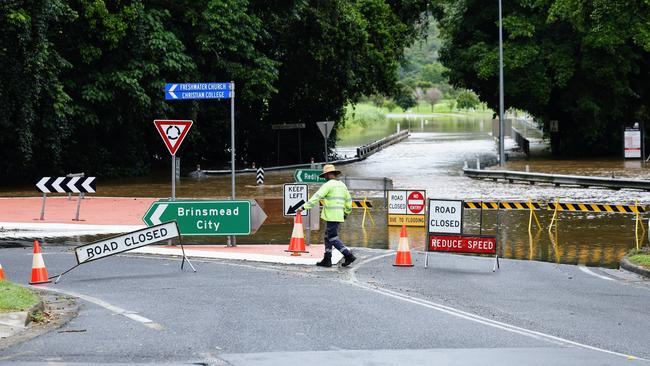 The roundabout at the intersection of Kamerunga and Brinsmead Roads was closed by traffic controllers after the road was submerged by flood water as Freshwater Creek overflowed due to the heavy rain falling in Cairns and on the Tablelands. Picture: Brendan Radke