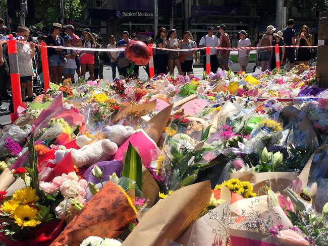 Visitors lay flowers at a floral tribute on Bourke St in Melbourne on January 22. Picture: Saeed Khan