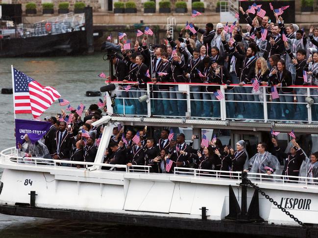 Team United States athletes wave flags on the team boat along the River Seine. Picture: Getty Images