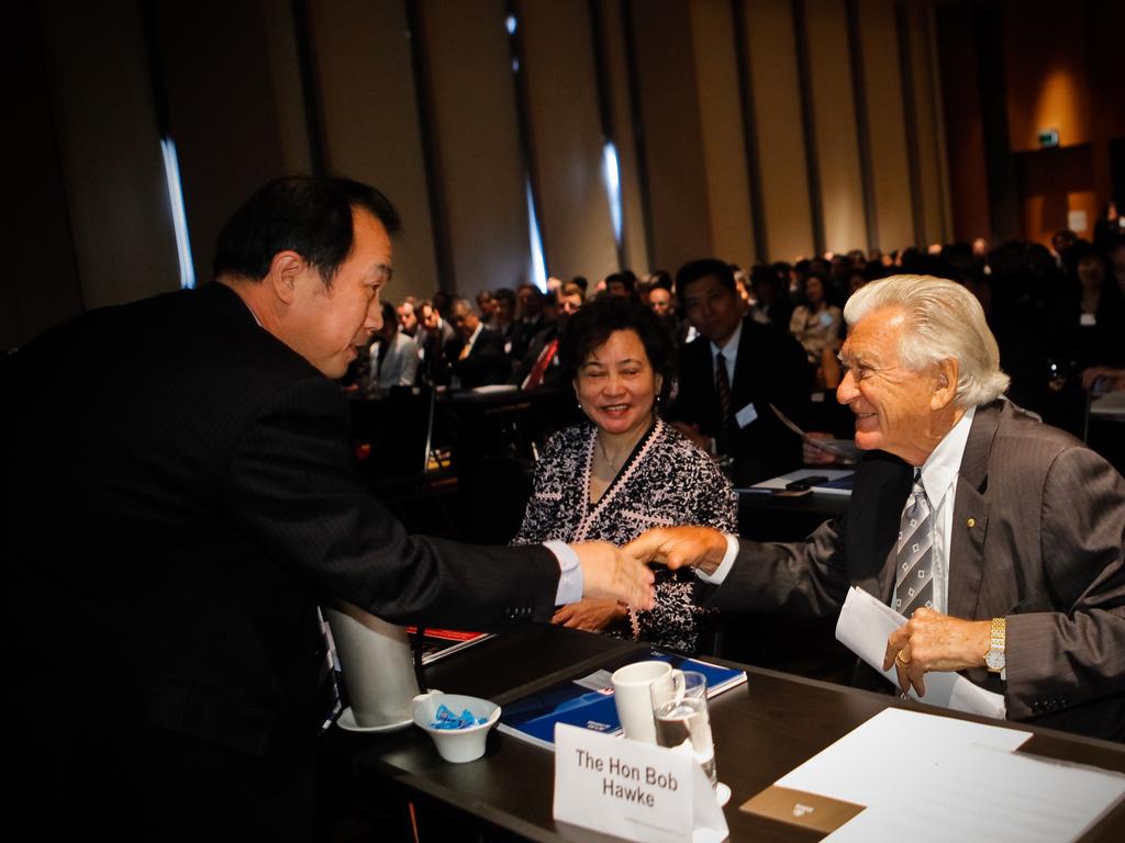 China's ambassador to Australia, HE Zhang Junsai, shakes hands with former Prime Minister Bob Hawke, at the Australia-China Business Council conference in Sydney.