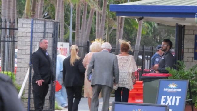 A woman is escorted from the Gold Coast Turf Club.