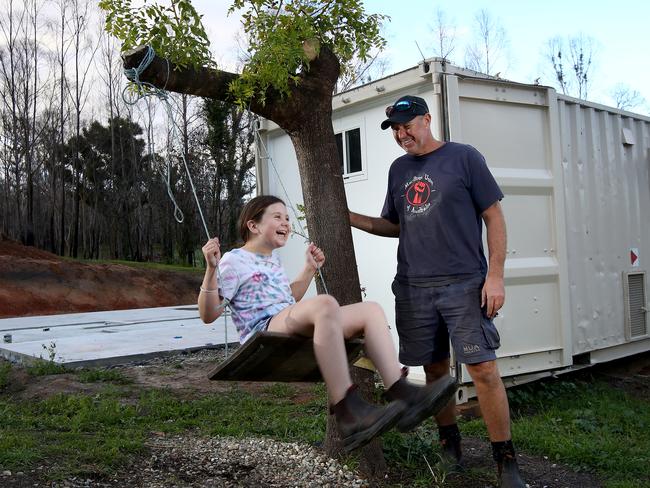 Tony Olsson and daughter Bella live in a temporary pod on their block near Cobargo, with a concrete slab having been poured ready for a new two bedroom home. Picture: Toby Zerna