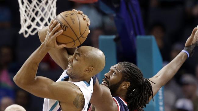 Hornets guard Gerald Henderson claims a strong rebound over the Wizards' Nene.