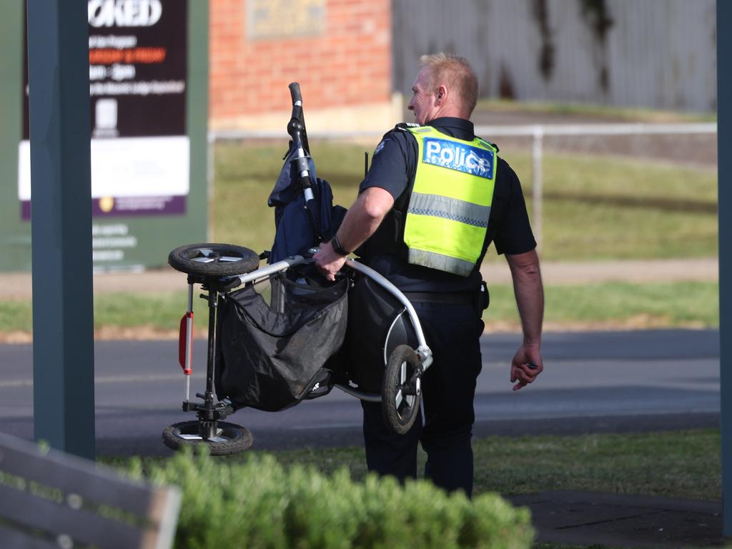 A police officer removes a pram from The Royal Daylesford Hotel on Monday. Picture: Brendan Beckett