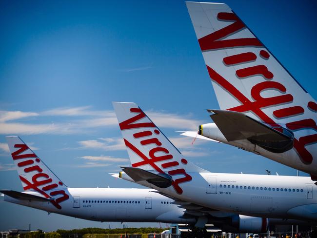 Virgin Australia aircraft are seen parked on the tarmac at Brisbane International airport on April 21, 2020. - Cash-strapped Virgin Australia collapsed on April 21, making it the largest carrier yet to buckle under the strain of the coronavirus pandemic, which has ravaged the global airline industry. (Photo by Patrick HAMILTON / AFP)