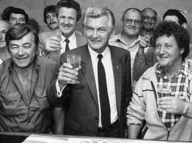 Prime Minister Bob Hawke shouts the bar at the Colac Hotel, Port Adelaide, during an unscheduled stop on his visit to Adelaide, 18 Apr 1984. Hawke is pictured with his glass of soda with Special Minister of State Mick Young on his right at the back.