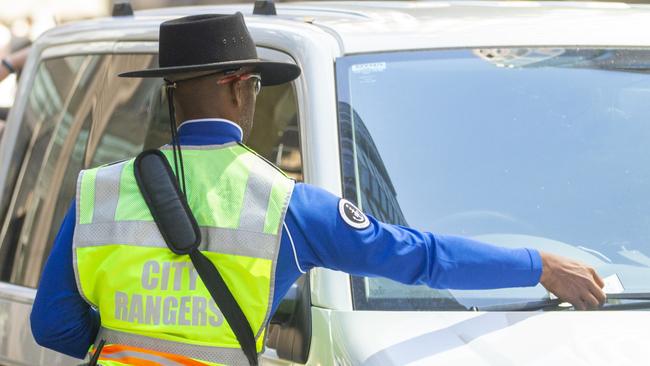 A city ranger is seen putting a parking fine on a car. Picture: NCA NewsWire / Jenny Evans