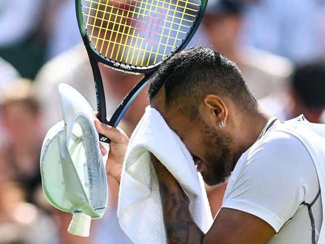 Australia's Nick Kyrgios uses a towel as he plays against US Brandon Nakashima during their round of 16 men's singles tennis match on the eighth day of the 2022 Wimbledon Championships at The All England Tennis Club in Wimbledon, southwest London, on July 4, 2022. (Photo by Glyn KIRK / AFP) / RESTRICTED TO EDITORIAL USE