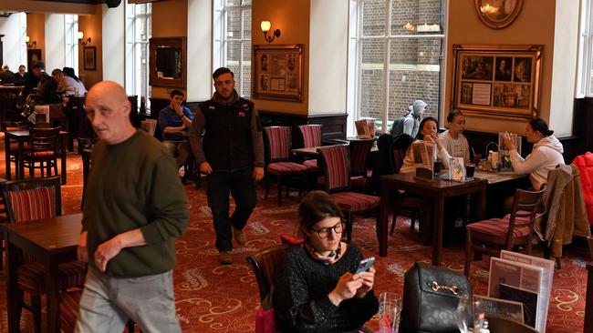 Customers sit at tables inside a pub in London. Picture: AFP