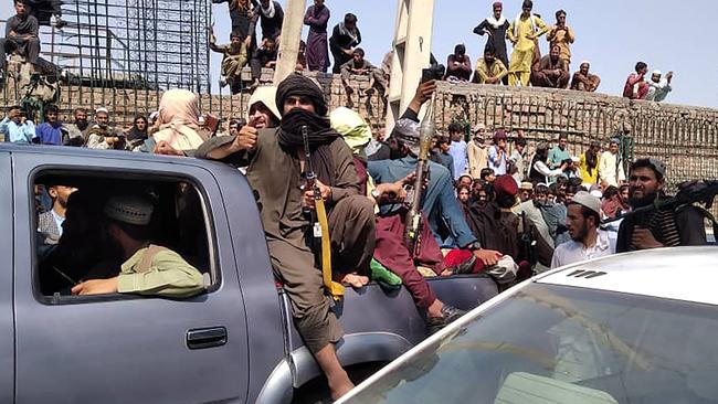 Taliban fighters sit on a vehicle along the street in Jalalabad province. Picture: AFP