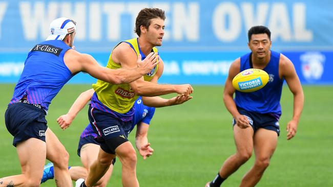 Josh Dunkley fires out a handpass during Western Bulldogs training at Whitten Oval. Picture: James Ross/AAP