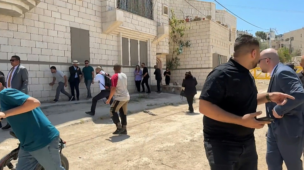 This frame grab from AFPTV footage shows members of a diplomatic delegation from the European Union reacting after shots were fired as they gathered in the eastern entrance of Jenin