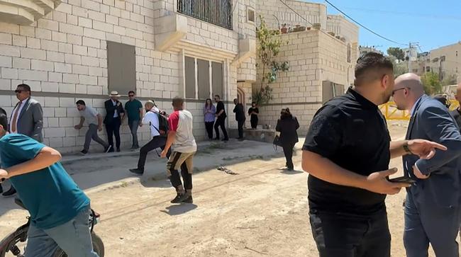This frame grab from AFPTV footage shows members of a diplomatic delegation from the European Union reacting after shots were fired as they gathered in the eastern entrance of Jenin