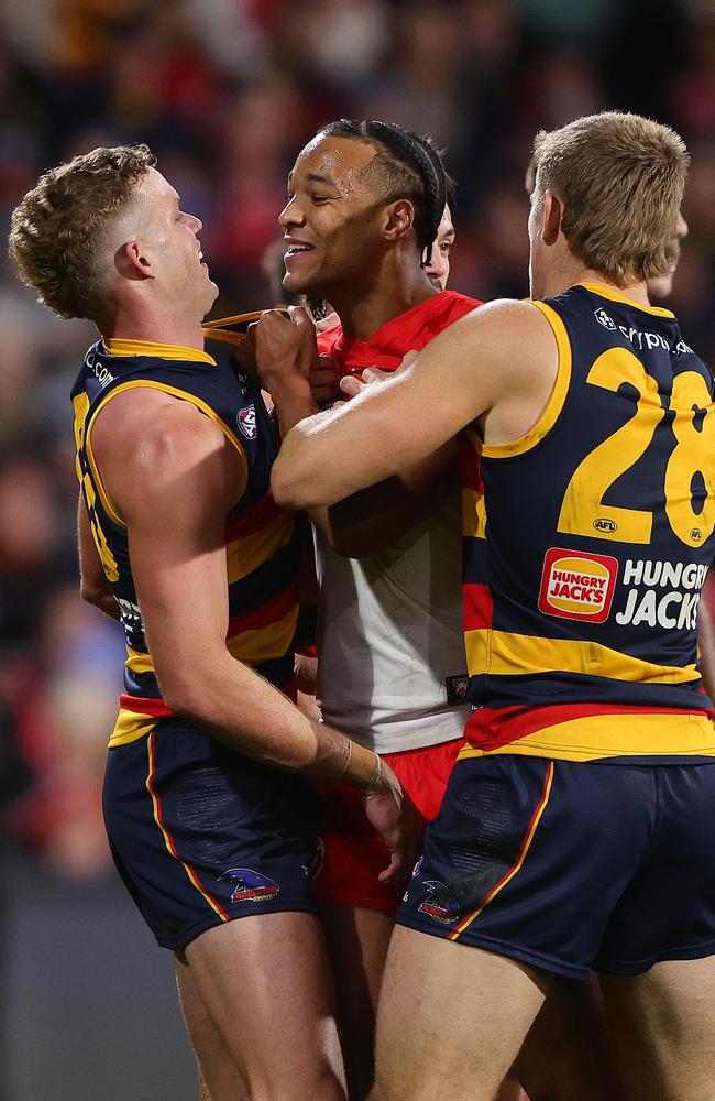 Joel Amartey, who booted nine goals, gets in the face of Crows Mitch Hinge and Nick Murray. Picture: Sarah Reed/AFL Photos via Getty Images