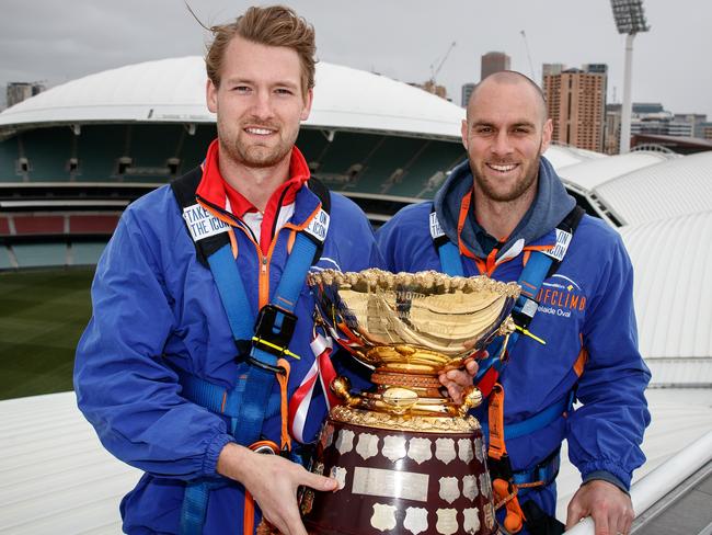 North Adelaide’s Lewis Hender and Norwood captain Jace Bode with the premiership cup on the Adelaide Oval roof. Picture: Matt Turner