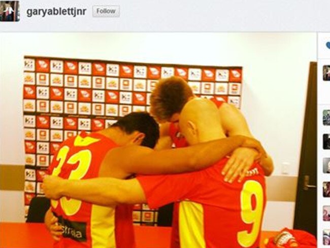 Gary Ablett prays with Suns teammates Aaron Hall and Zac Smith before Gold Coast’s match against the Western Bulldogs in 2013.