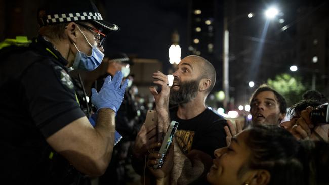 Anti-lockdown protesters face off with police in front of Victoria’s Parliament House on Friday. Picture: Getty