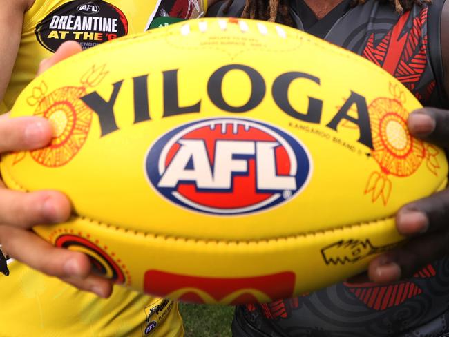 WARNING EMBARGO until Monday 15th MAY 2023. SEE PIC DESK Sherrin changing ball for Sir Doug Nicholls Round (Round 10) Indigenous AFL stars Daniel Rioli and Anthony McDonald-Tipungwuti, hold the SDNR Sherrin artwork designed by Tiwi woman Lulu Coombes.     Picture: David Caird