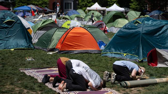 Pro-Palestinian students and activists pray at the encampment on the campus of George Washington University. (Photo by Drew ANGERER / AFP)