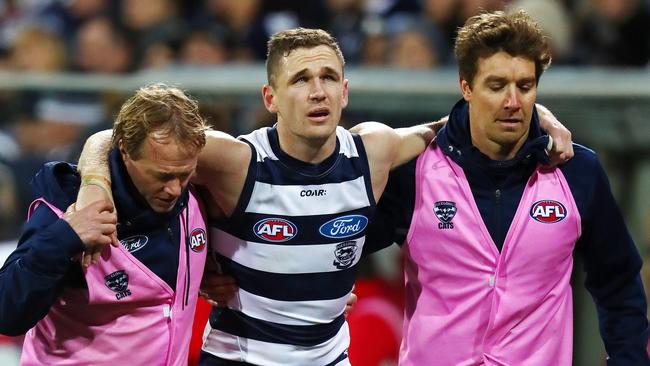 Geelong's Joel Selwood in the hands of trainers after injuring his ankle. Picture: Michael Klein