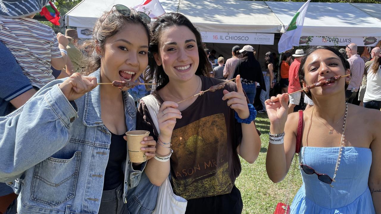 Panmai Rasitanon, Emy Mochi and Eleonora Bianco eating arrosticini at the La Festa - Food and Wine day as part of Cairns Italian Festival at Fogarty Park. Picture: Andreas Nicola