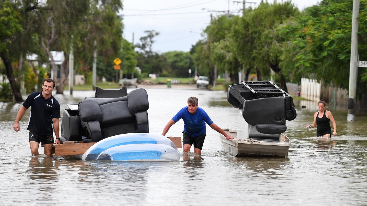 Residents use a boat and an inflatable pool to salvage furniture from flood-affected homes in Townsville during 2019 flooding. Picture: AAP Image/Dan Peled.